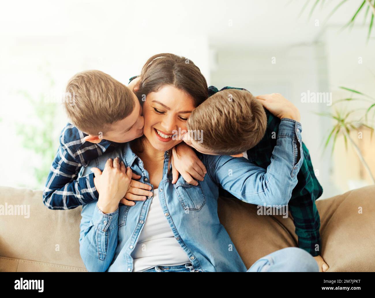 child son mother family happy playing kid childhood mom love fun smiling little woman home brother parent Stock Photo