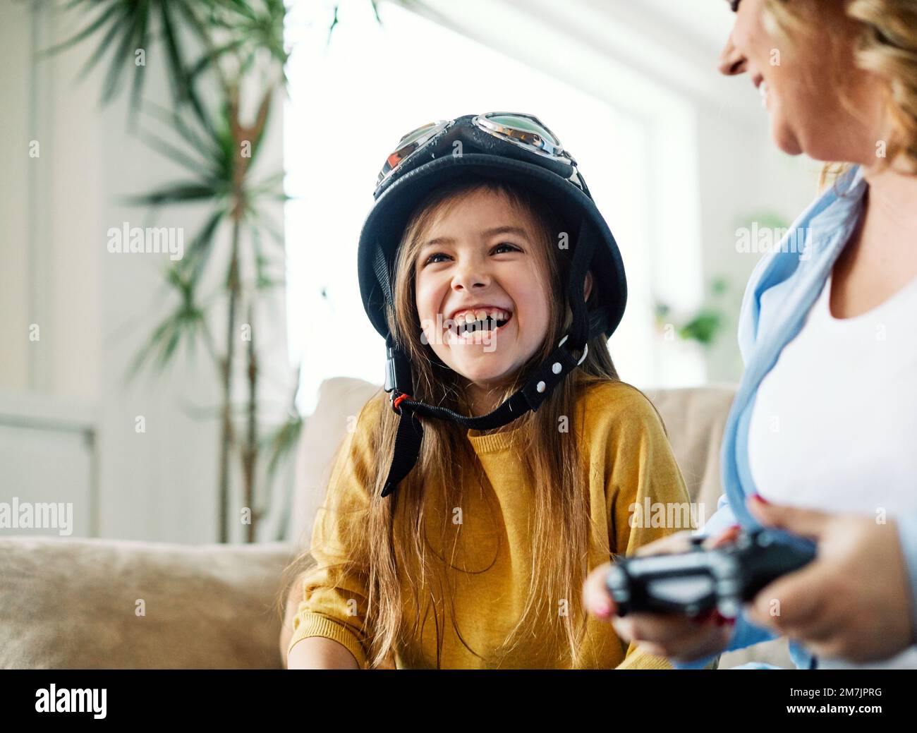 child daughter mother family happy playing console kid childhood joystick cotroller Stock Photo