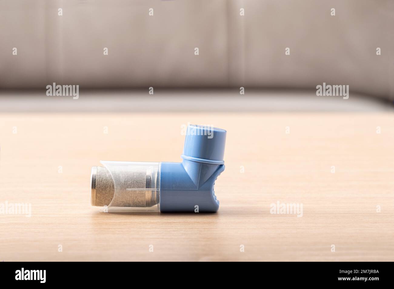 Close-up of asthma inhalers with blank label on wood table. Pharmaceutical product is used to treat lung inflammation and prevent asthma attack for as Stock Photo