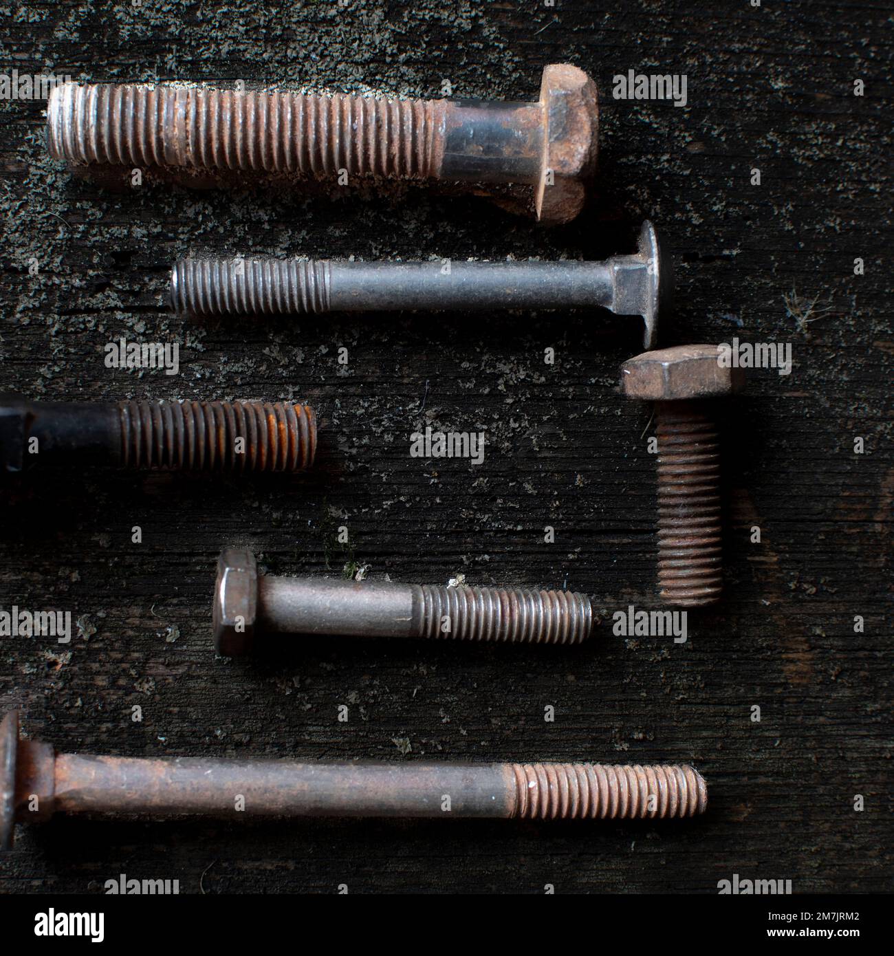 Top view of the rusty and old nut bolts and screws put on the grunge table surface Stock Photo