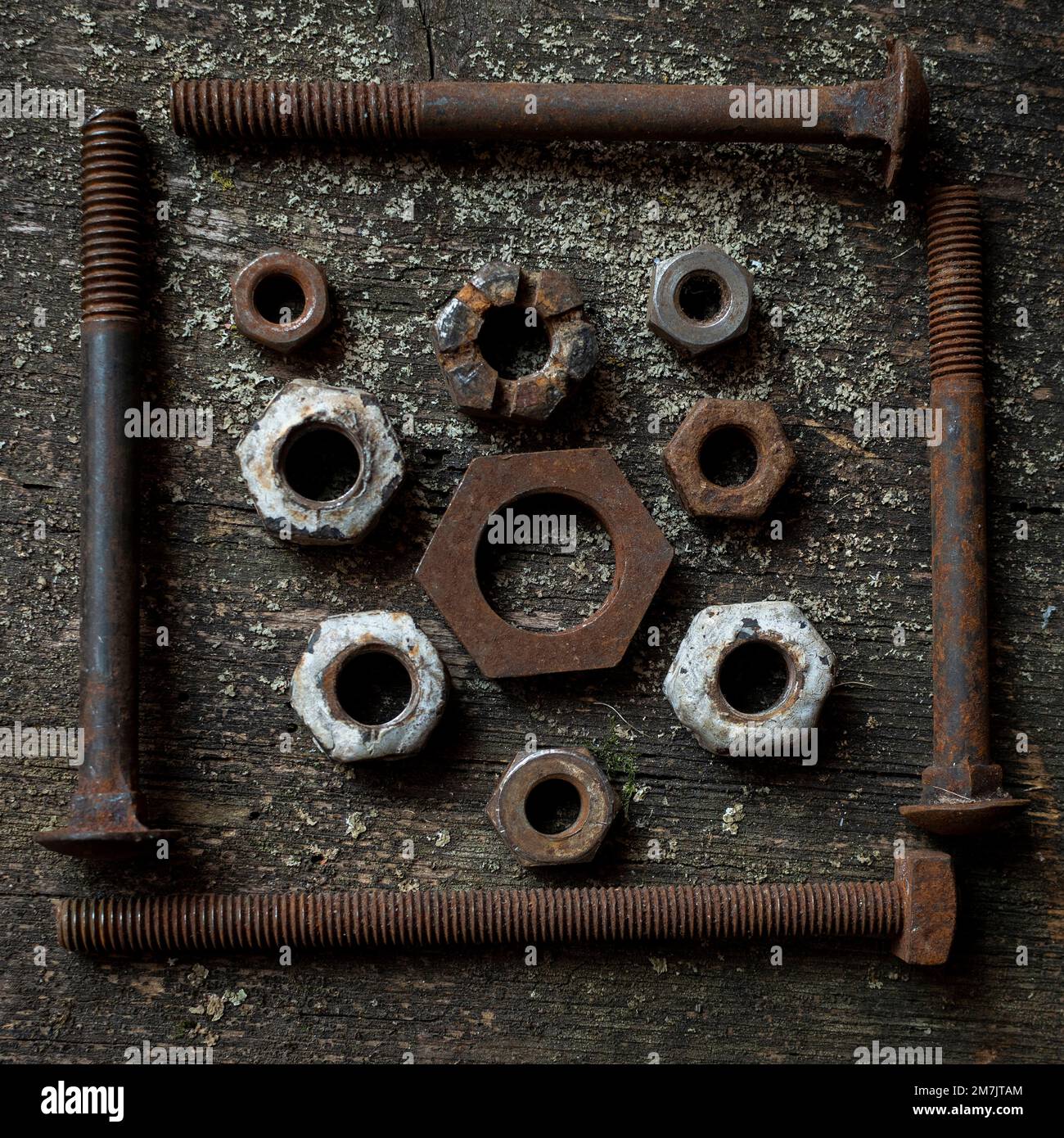 Top view of the rusty and old nut bolts put on the grunge table surface Stock Photo