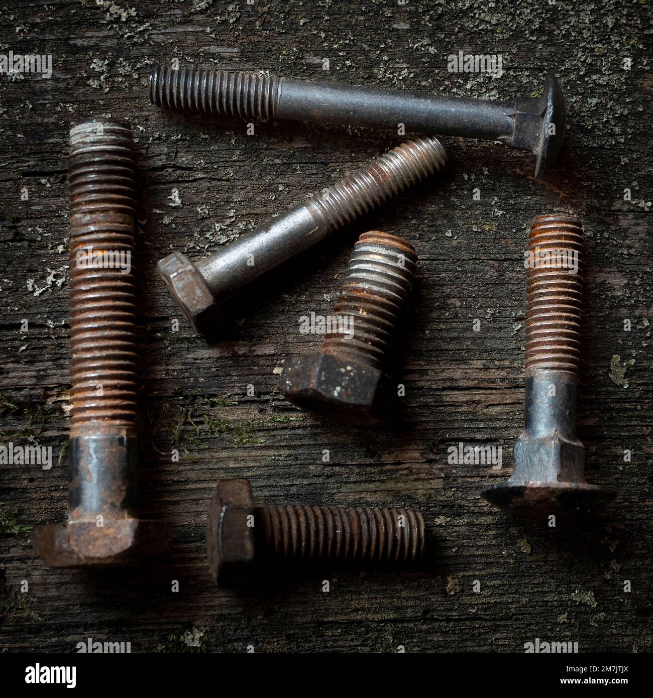 Top view of the rusty and old nut bolts and screws put on the grunge table surface Stock Photo