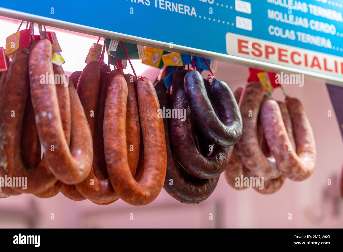 Cured meats hanging in stall at local food market in Jerez de la