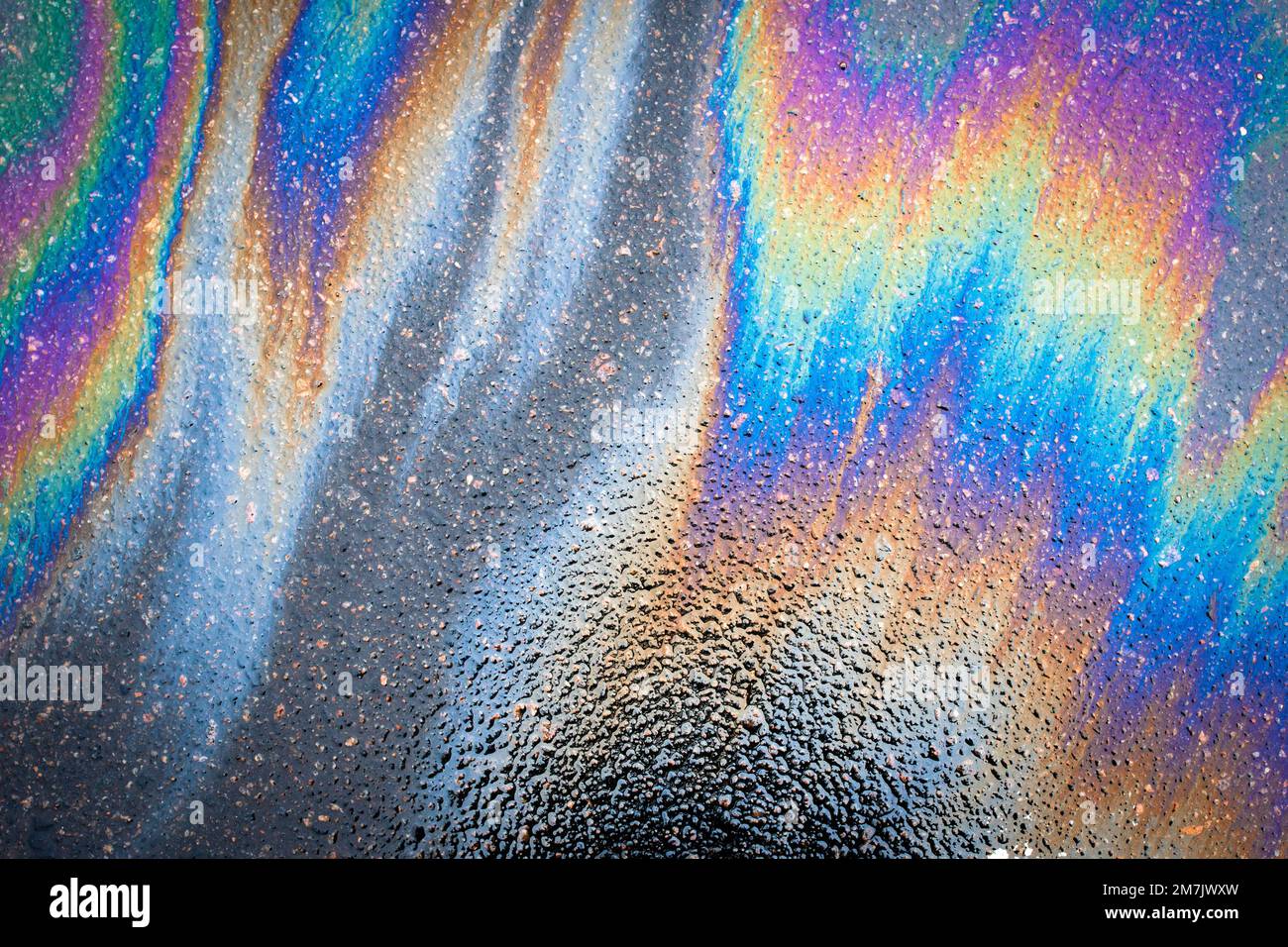 Oil stains from leaks in the car engine. Oil after rain makes spots