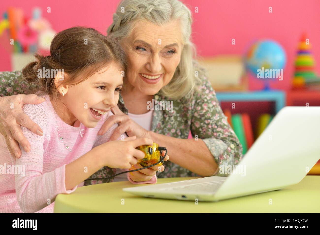 granny with her granddaughter playing computer game Stock Photo