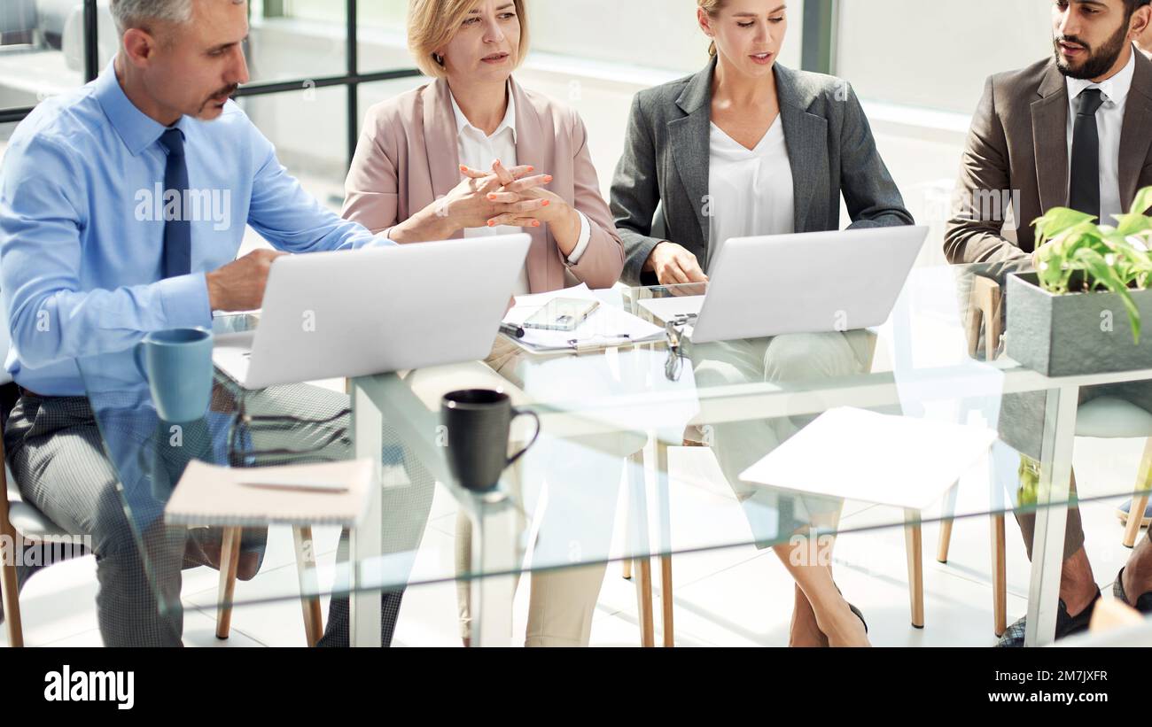 group of business people discussing something while sitting at a Stock Photo