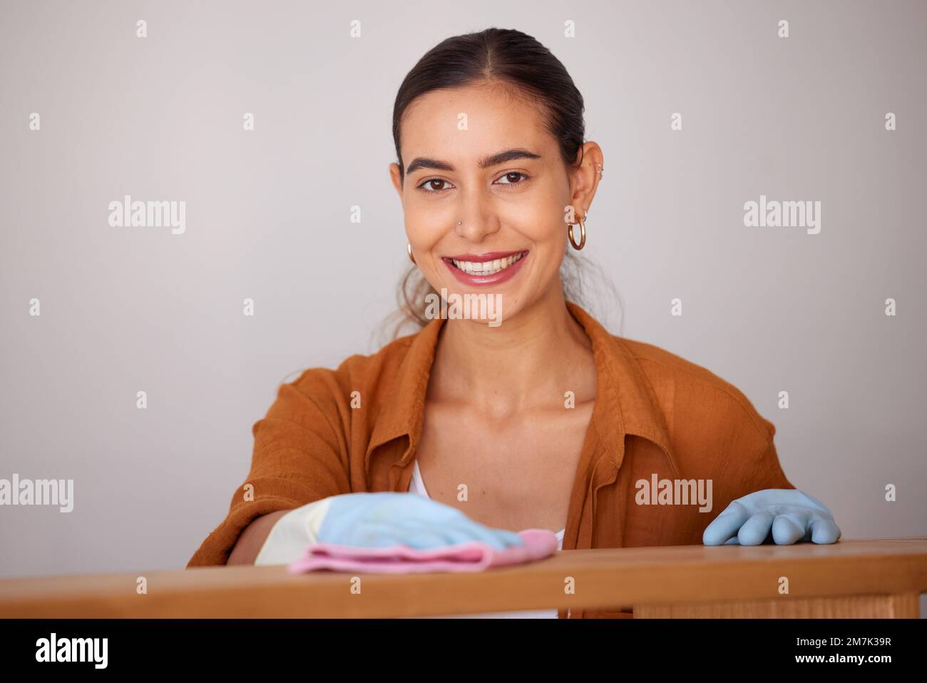 Portrait, cleaning and wipe with a woman housekeeper or cleaner using a