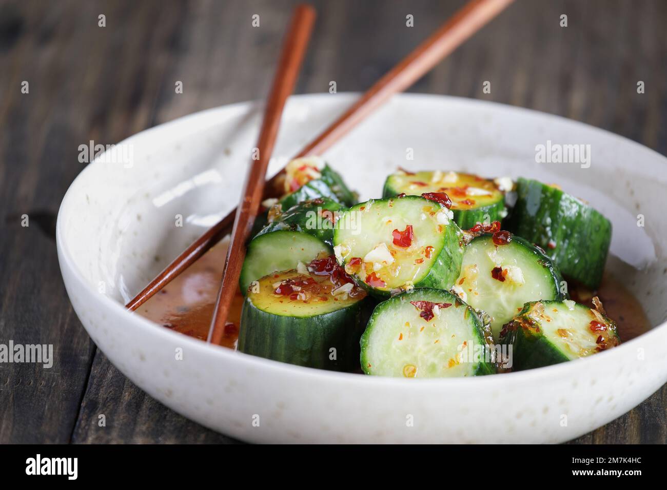 Easy Spicy Korean Cucumber Salad, Oi Muchim, made with garlic and hot peppers. Extreme selective focus with blurred foreground and background. Stock Photo