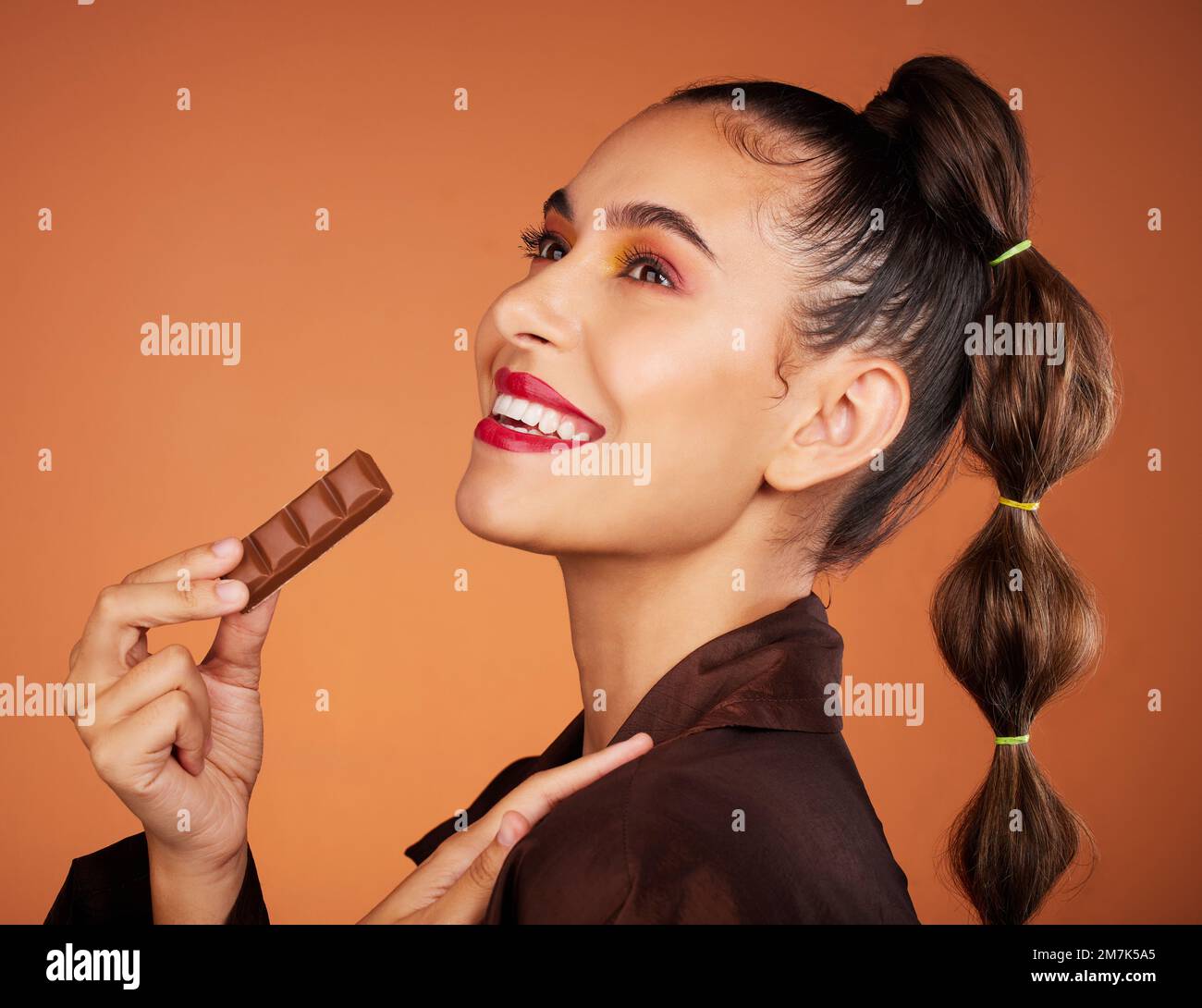Beauty, eating and profile woman with chocolate bar, junk food or dessert for sugar sweets, candy snack or cheat meal. Face makeup, skincare cosmetics Stock Photo