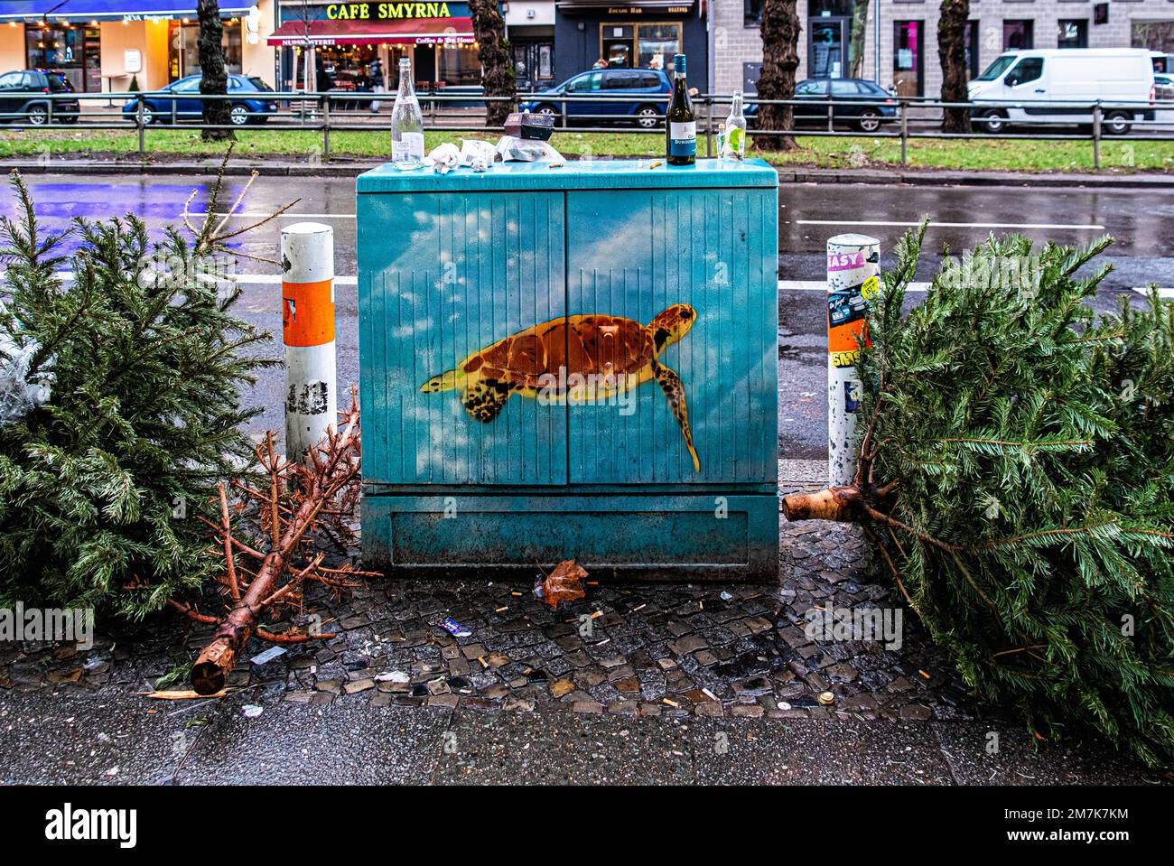 Dumped Christmas trees next to painted utility box in Hauptstrasse, Schöneberg, Berlin, Germany Stock Photo