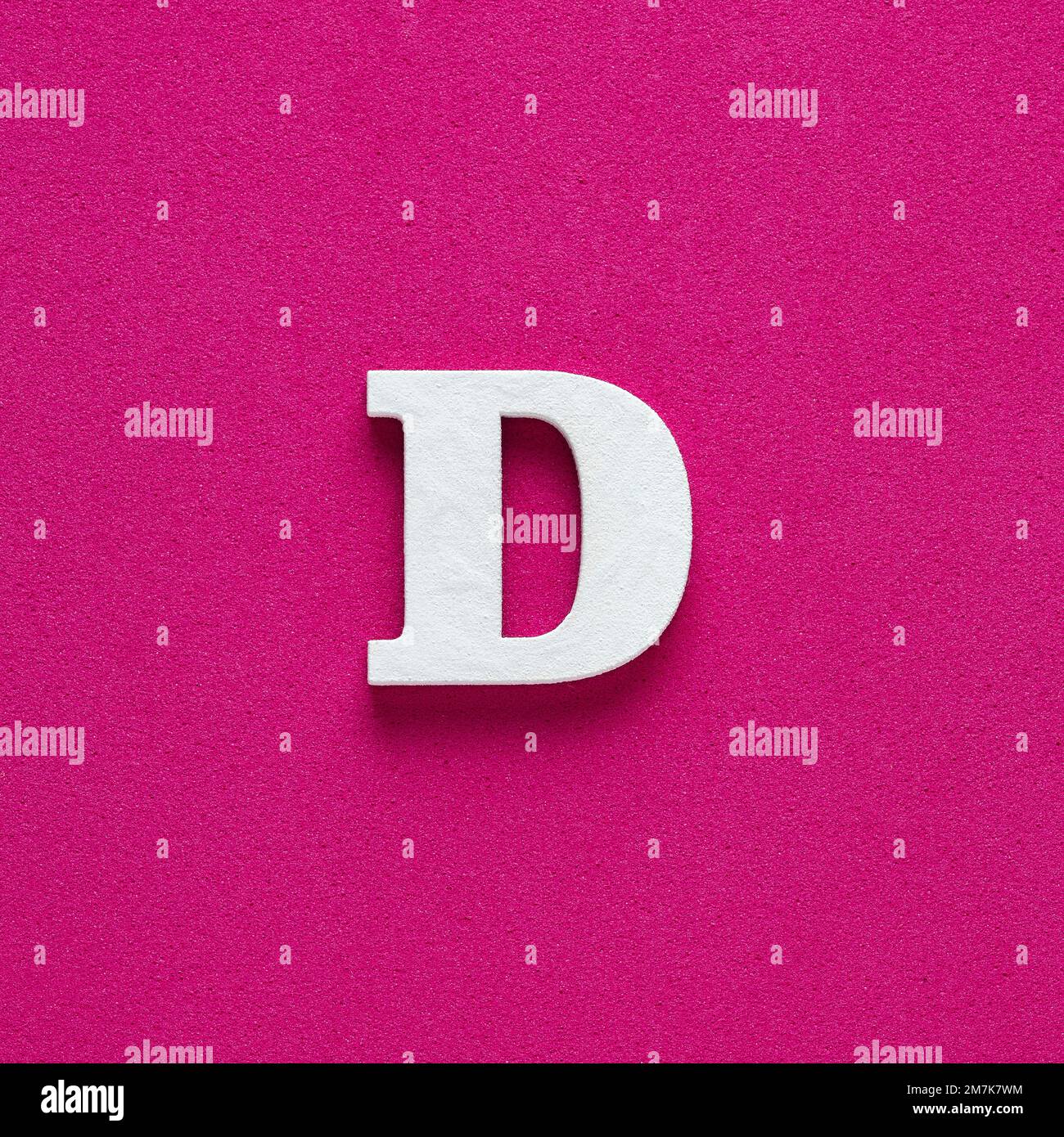 Letter D uppercase White wood font on rhodamine red background Stock