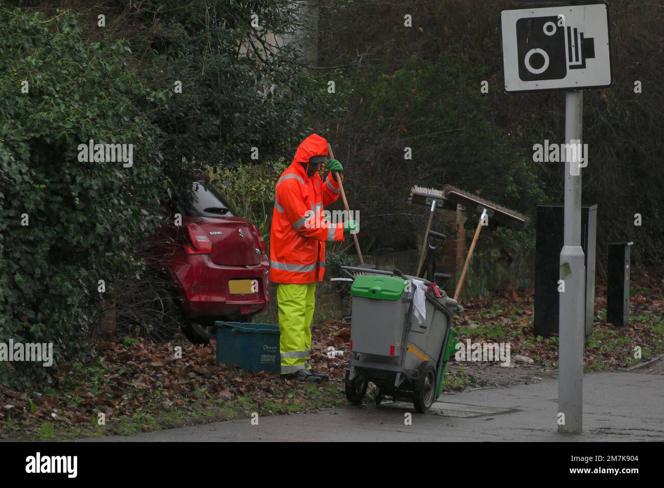 Road Sweeper clearing the pavements in the rain in winter in South London, England Stock Photo