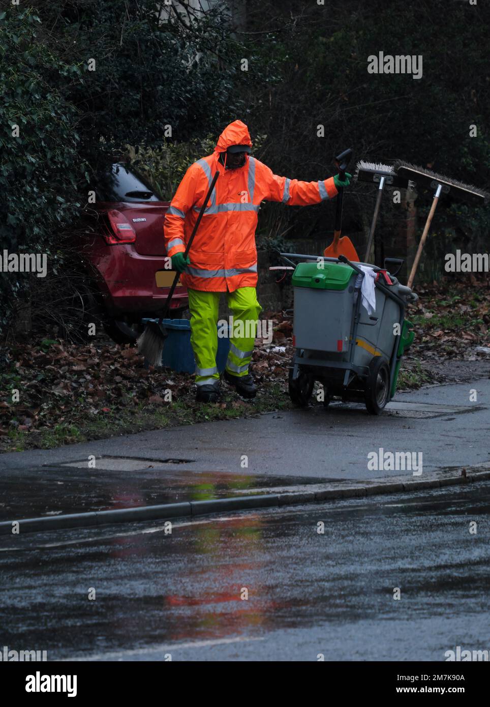 Road Sweeper clearing the pavements in the rain in winter in South London, England Stock Photo