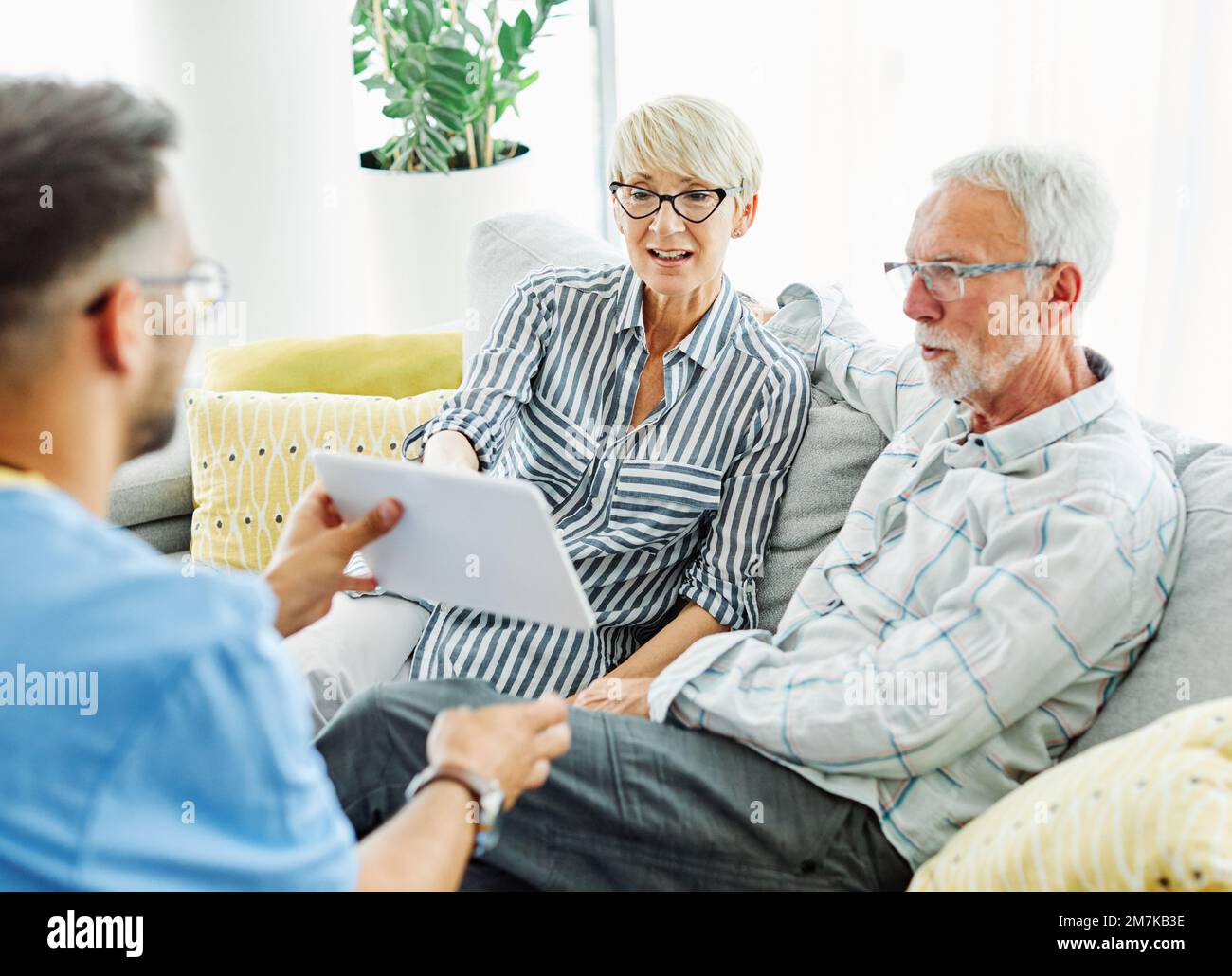 nurse doctor senior couple care caregiver help assistence retirement home nursing elderly man woman tablet technology Stock Photo