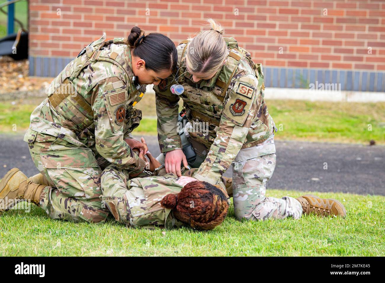Airman 1st Class Helen Lopez, left, 423d Security Forces Squadron installation patrolman, and Airman 1st Class Sierra Capobianco, base defense operations center controller, demonstrate apprehending a suspect at RAF Molesworth, England, May 10, 2022. The 423d SFS taught students from Huntingdon’s St. Peter’s school about weapons safety and self defense techniques as part of a mentorship program aimed at strengthening the relationship between the 501st Combat Support Wing and local community. Stock Photo