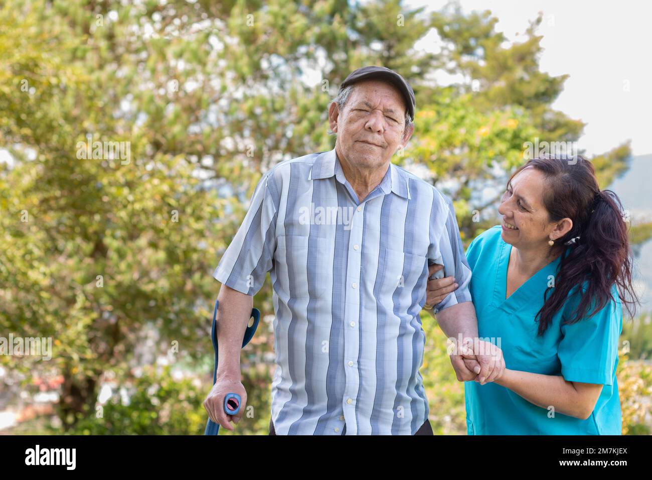Caregiver helps a disabled elderly man to walk. Nurse assists an