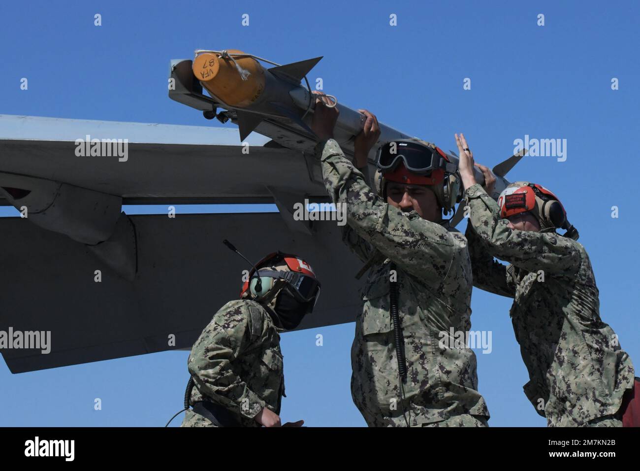 U.S. Sailors assigned to Strike Fighter Squadron (VFA) 83 remove an AIM ...