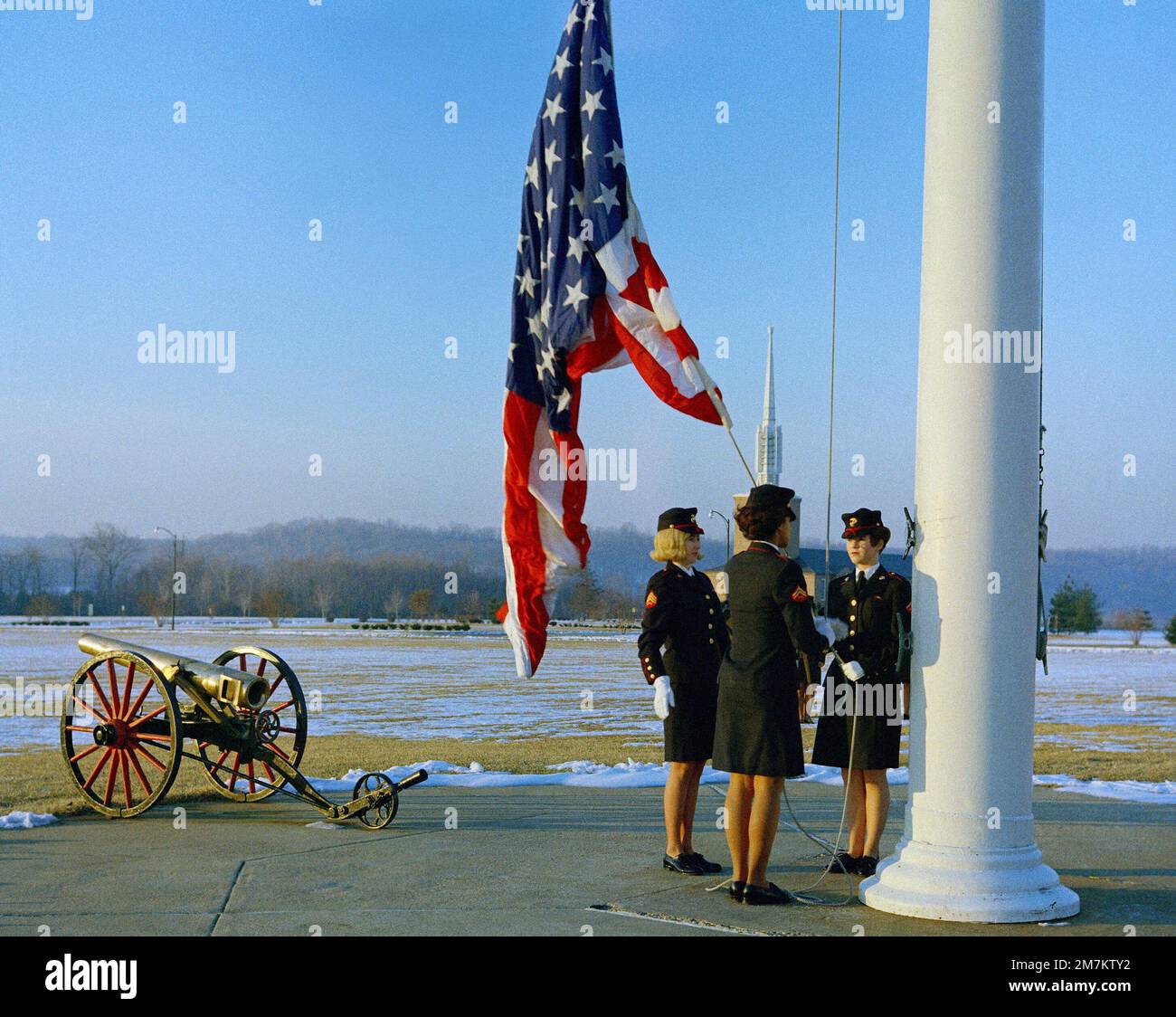 Three female Marines, in dress blue uniforms, raise the morning colors