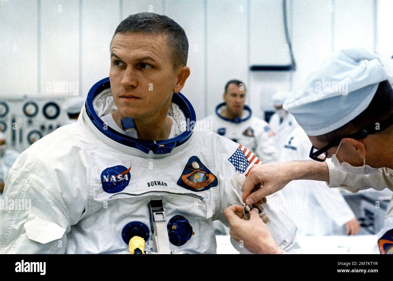 A technician places two inflight pens and a penlight in the spacesuit pocket of Frank Borman, Apollo 8 commander. In approximately four hours, Borman and fellow Apollo 8 astronauts James Lovell and William Anders are scheduled to lift off on a lunar orbiting mission. Base: Kennedy Space Center State: Florida (FL) Country: United States Of America (USA) Stock Photo