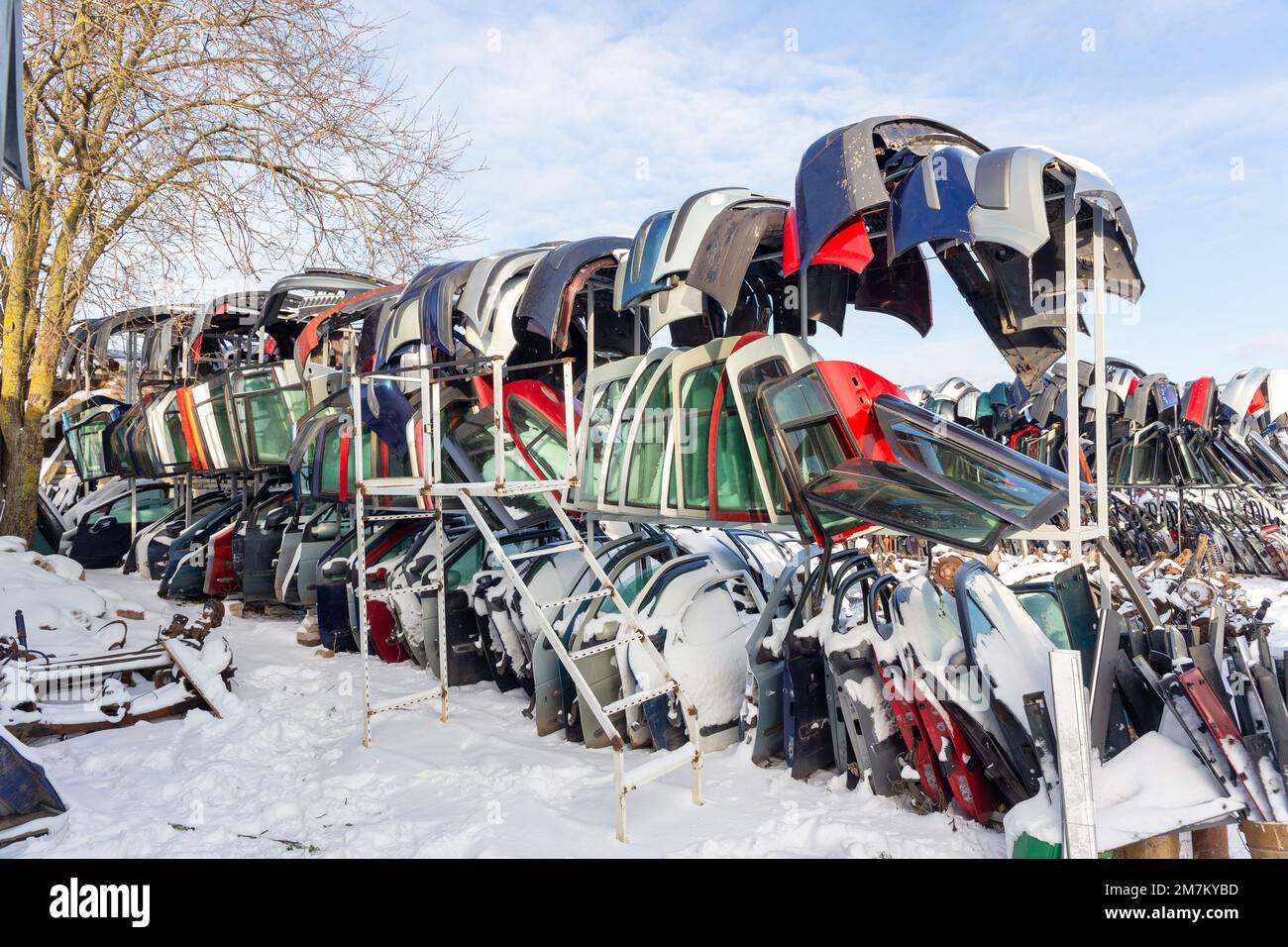 Disassembled cars on a car dump are on sale for spare parts. A stack of doors and bumpers. Trade in used spare parts is a common business in developin Stock Photo
