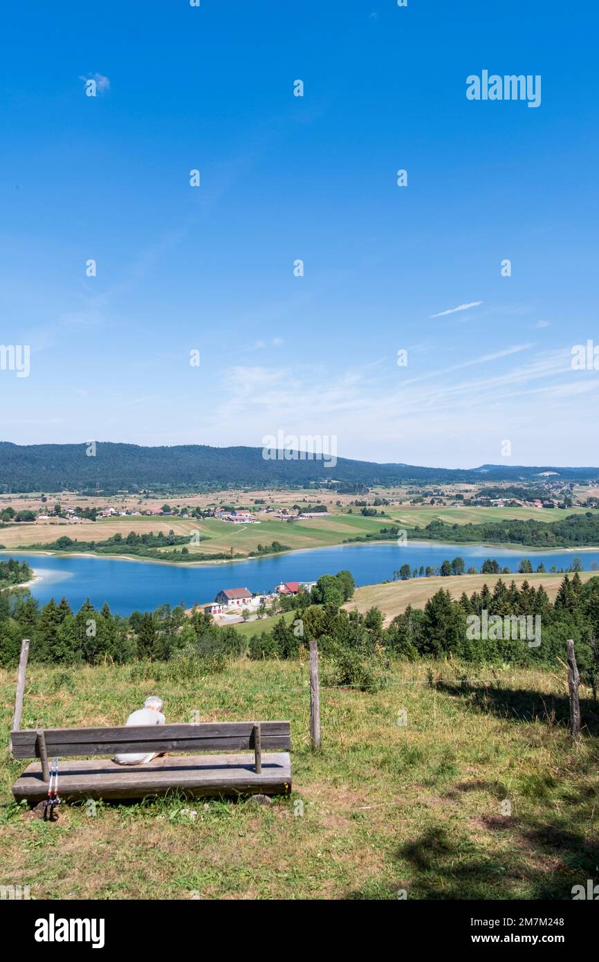 Grande-Riviere Chateau (central-eastern France): panoramic view of the lake of the Abbey from the belvedere “belvedere du Moulin”. Elderly woman sitti Stock Photo
