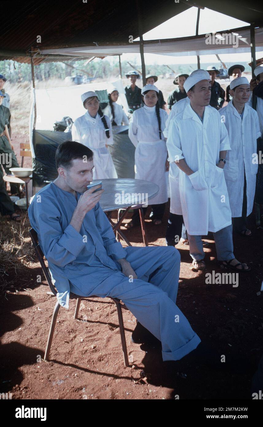 Surrounded by Viet Cong medical personnel, injured American POW, CPT David Earle Baker, (Captured 27 June 72) sits in the hospital tent prior to being turned over the American authorities. CPT Baker was one of the 27 American POWs who were released during the exchange of POWs by the Four Power Joint Military Commission. Subject Operation/Series: HOMECOMING Base: Loc Ninh Country: South Vietnam Stock Photo