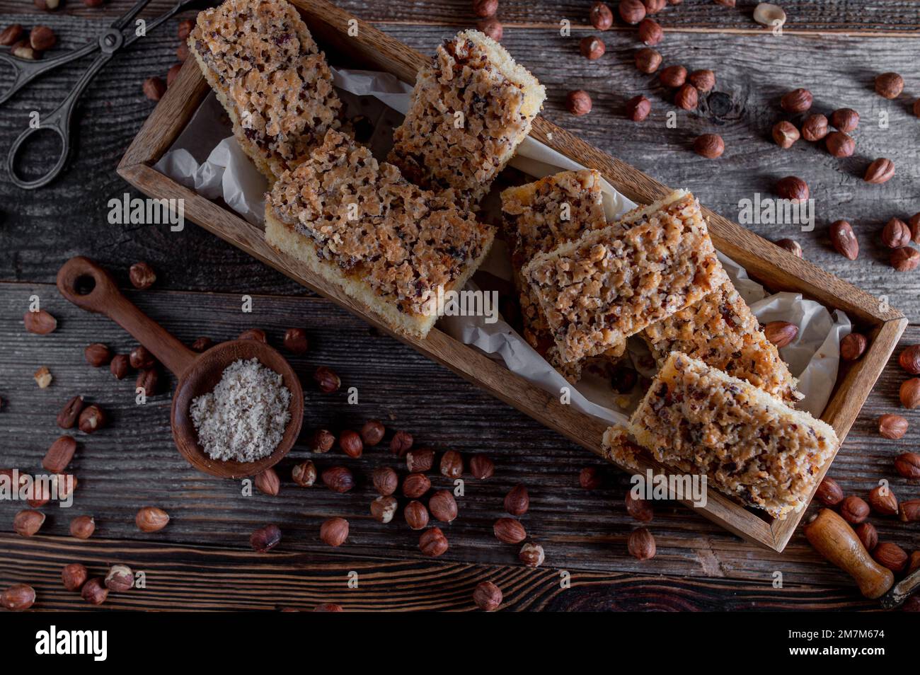 Nut cake with caramelized hazelnuts on wooden background. Flat lay Stock Photo