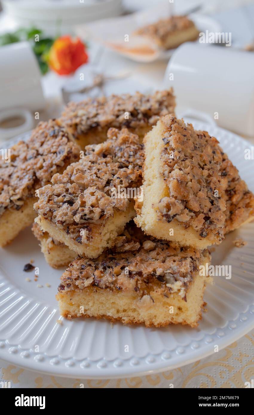 Sheet sponge cake with crunchy hazelnut topping on a white table Stock Photo