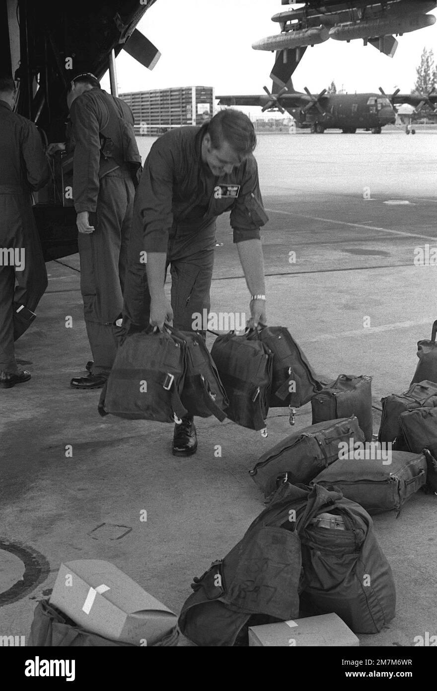 Crew members load life rafts aboard an AC-130H Hercules aircraft while ...