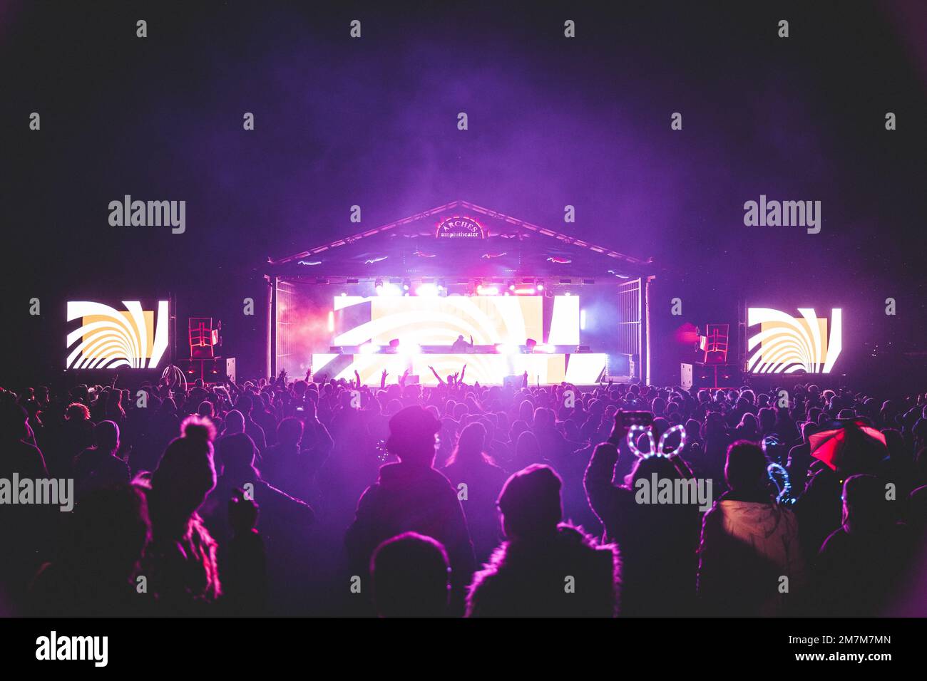 Night time music festival with large crowd and fun lights Stock Photo