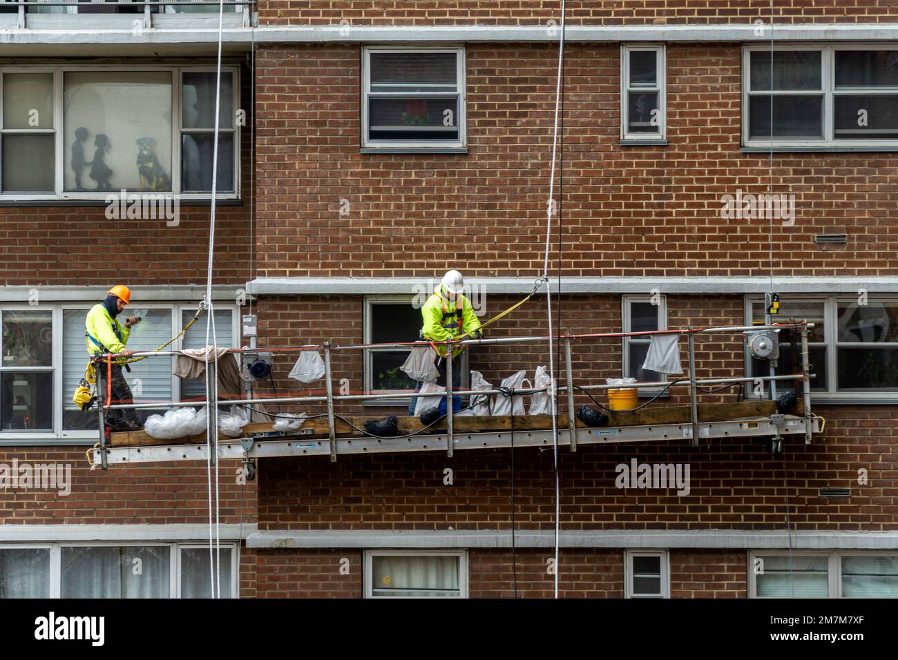 Workers on scaffolding perform citymandated facade inspection and repair on the exterior of an