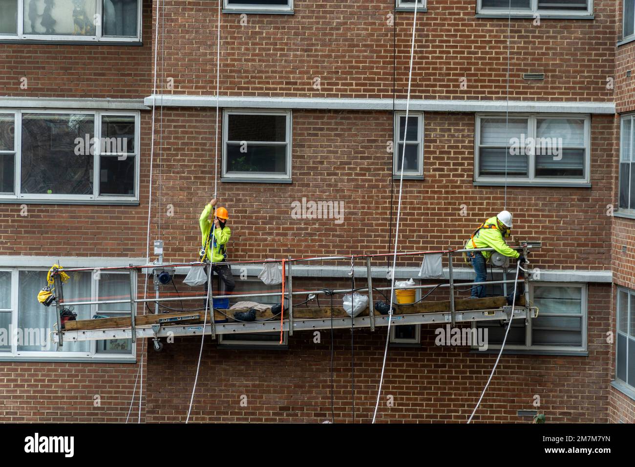 Workers on scaffolding perform citymandated facade inspection and repair on the exterior of an