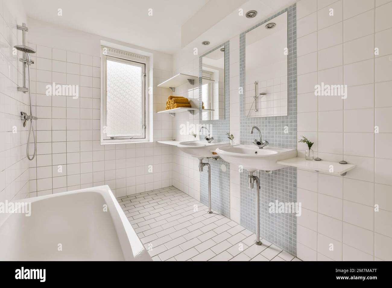 a bathroom with blue and white tiles on the walls, tub, sink and shower stall in front of the mirror Stock Photo
