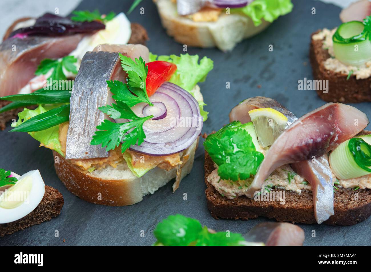 Toasts with salted herring, pate, onion, egg, lettuce, tomato and beetroot. Scandinavian cuisine
