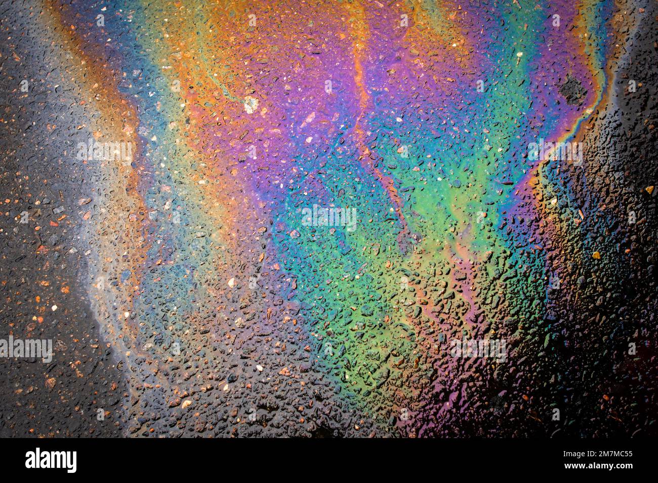 Oil stains from leaks in the car engine. Oil after rain makes spots