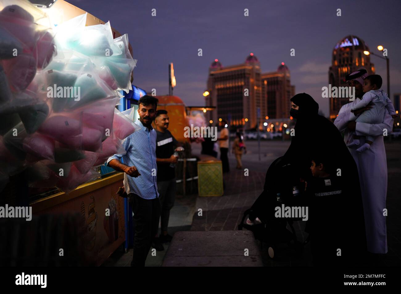 A woman buys candy cotton at a shop in Katara beach in Doha, Qatar, Thursday, Dec. 8, 2022. (AP