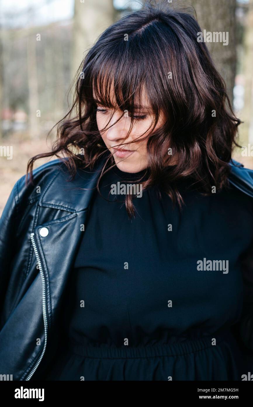 Young woman looking down in forest Stock Photo