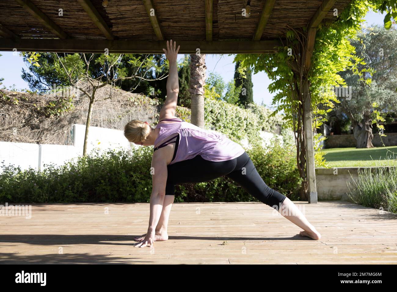 Woman practicing yoga in a garden in Mallorca, Spain Stock Photo