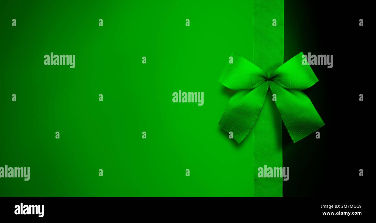Green ribbon bow against green background Stock Photo