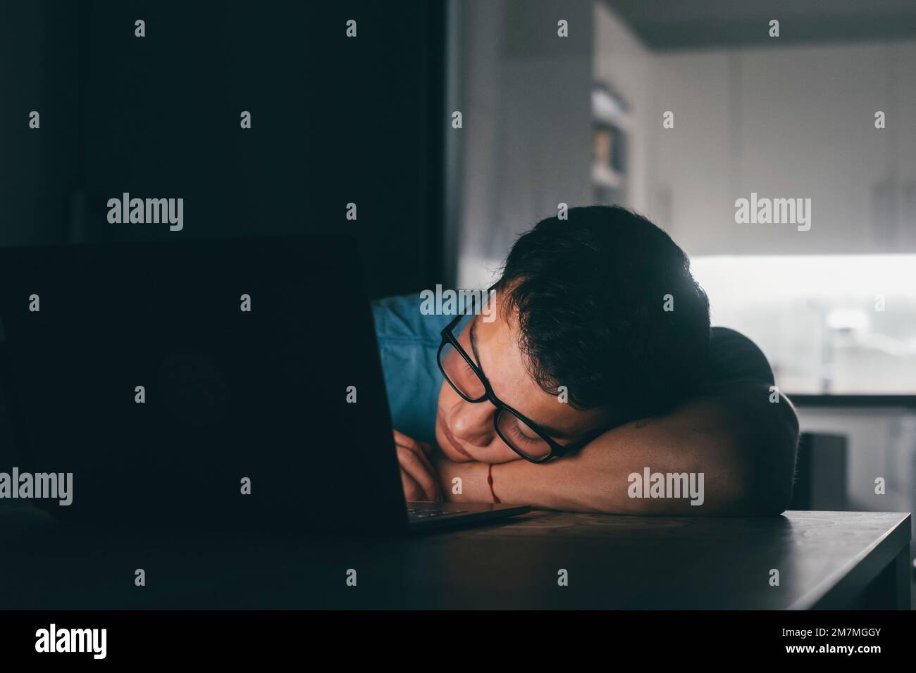 Close up business man put head on folded hands sleeping at workplace at night. Overloaded office employee tired of routine monotony paperwork. Unmotivated worker, insomnia and chronic fatigue syndrome concept Stock Photo