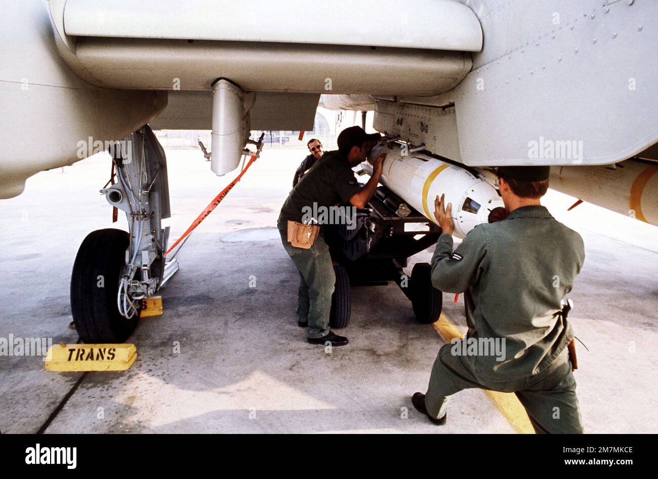 Ground crewman attach a live Mark 20 anti-tank cluster bomb to the wing ...