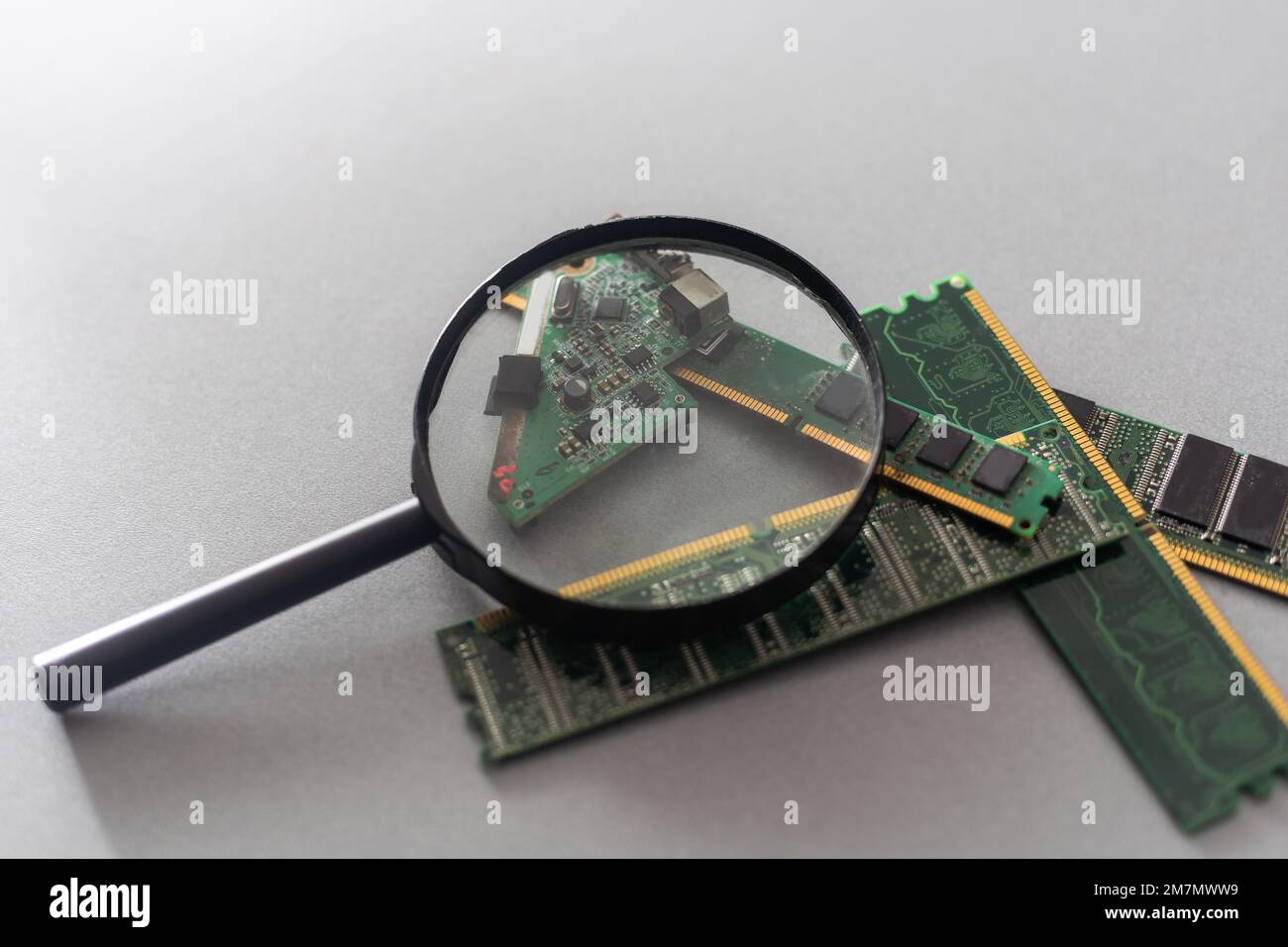 Green computer chip with a magnifying glass close-up. Stock Photo
