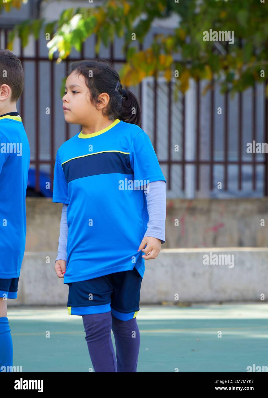 latin girl football player in a sport suit on a soccer field at a elementary children soccer match Stock Photo