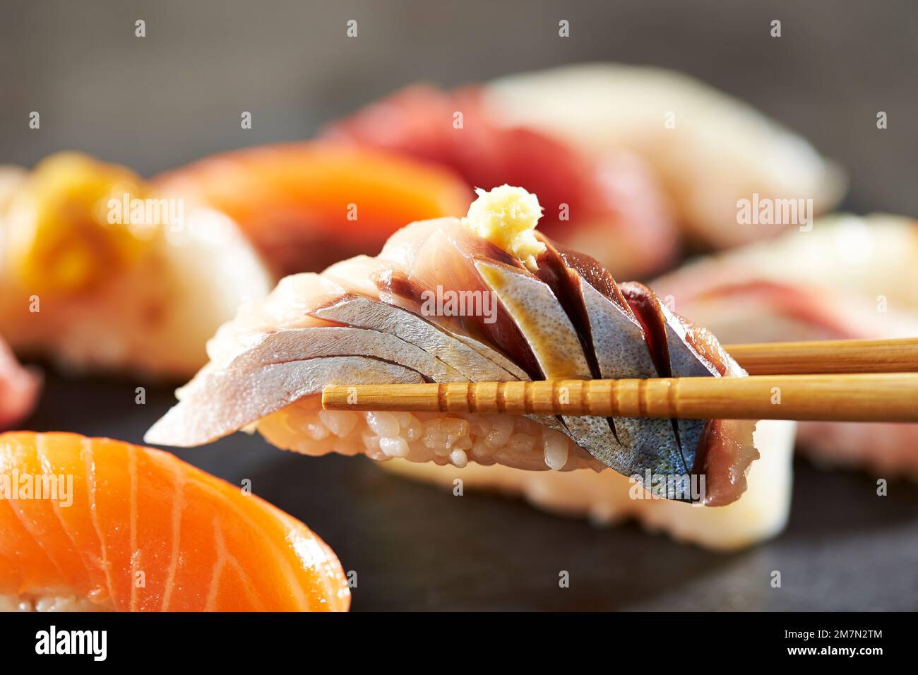 Horse mackerel sushi on chopsticks Stock Photo Alamy