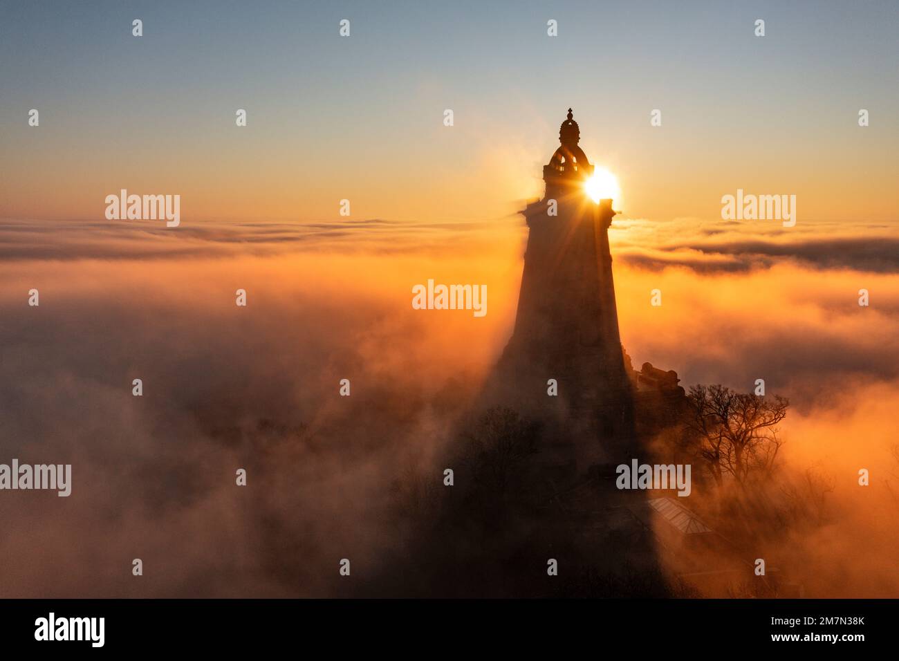 Germany, Thuringia, Bad Frankenhausen, tower of Kyffhäuser monument rises from low clouds, sunrise, back light Stock Photo