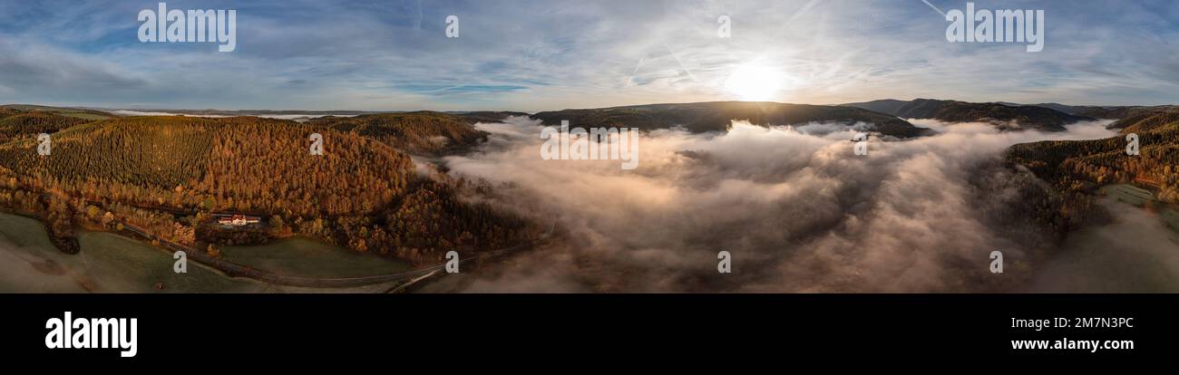 Germany, Thuringia, Schwarzburg, fog lies over the Schwarzatal, faintly shimmers the castle through the fog, train station, forest, mountains, valleys, sunrise, overview, aerial view, partly backlight, 36ö° - Panorama Stock Photo