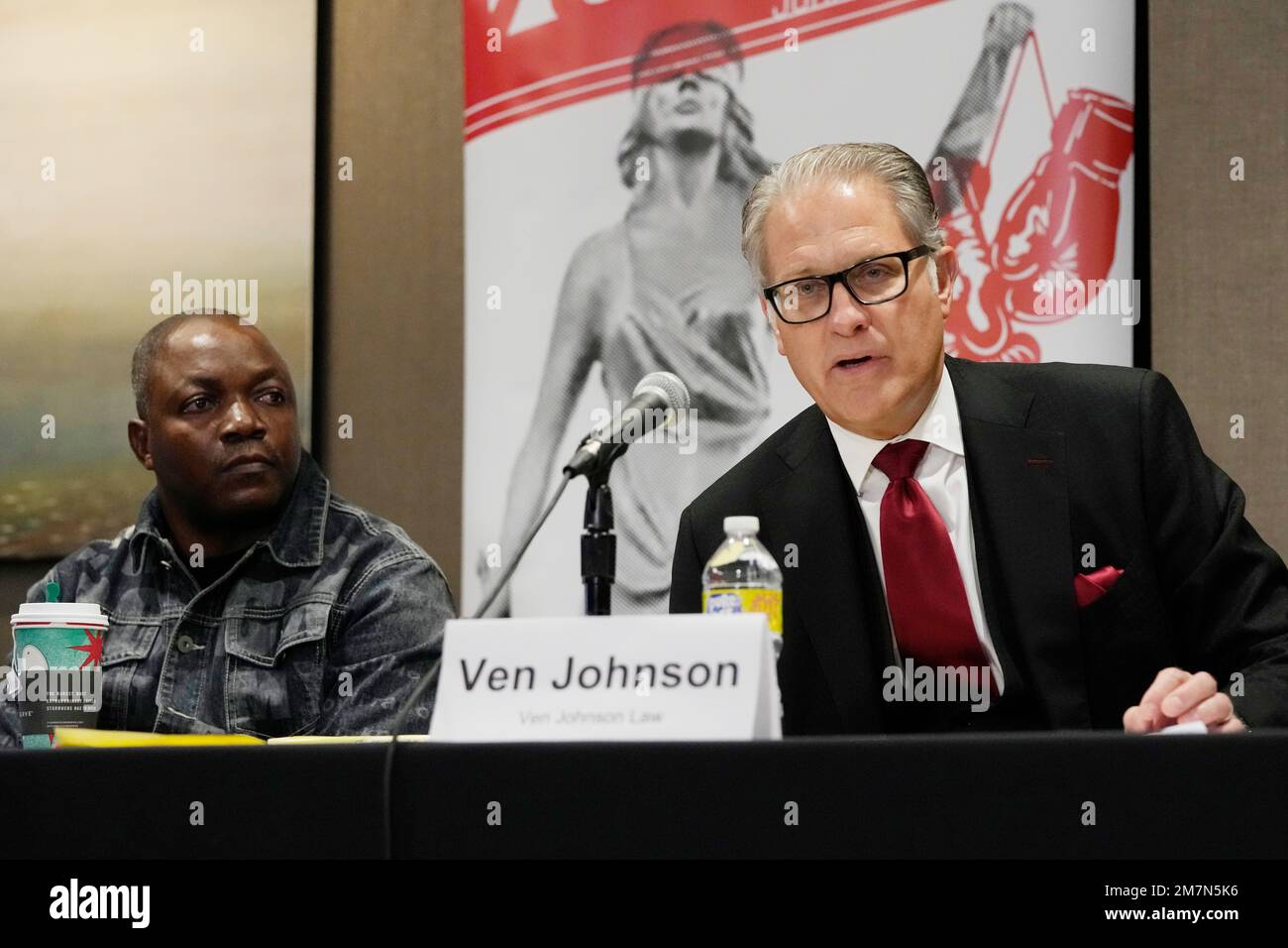Attorney Ven Johnson sitting next to Peter Lyoya announces the filing