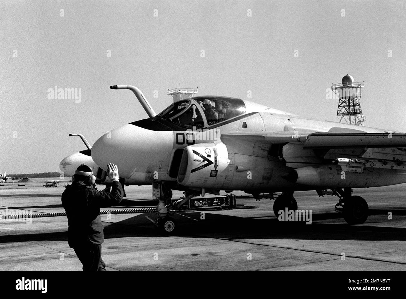 A flight line plane captain directs the pilot of an A-6E Intruder aircraft to a parking spot on the flight line of Marine All-Weather Medium Attack Squadron 533. Base: Mcas, Cherry Point State: North Carolina (NC) Country: United States Of America (USA) Stock Photo