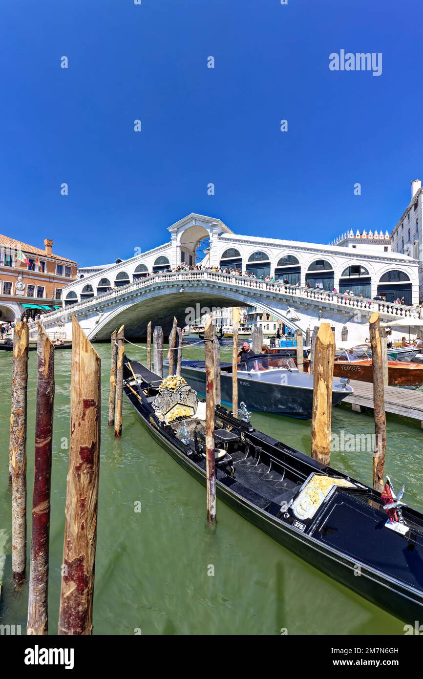 The Rialto Bridge in Venice is one of the landmarks of the Italian lagoon city, in front of it lies a moored gondola Stock Photo