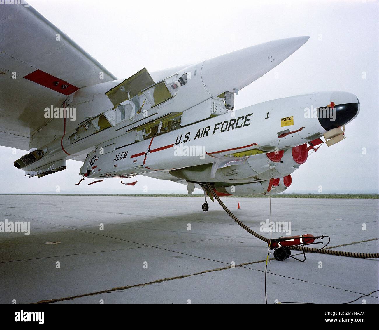 A close-up view of an AGM-86 air-launched cruise missile loaded on a B-52 Stratofortress aircraft wing pylon. Country: Unknown Stock Photo